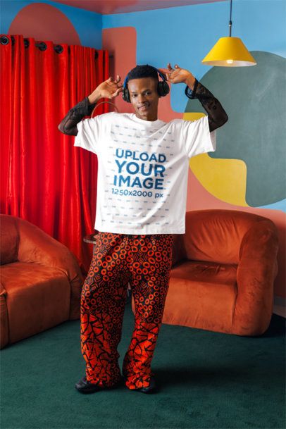 Oversized T-Shirt Mockup of a Man With Headphones Dancing in a Colorful Living Room