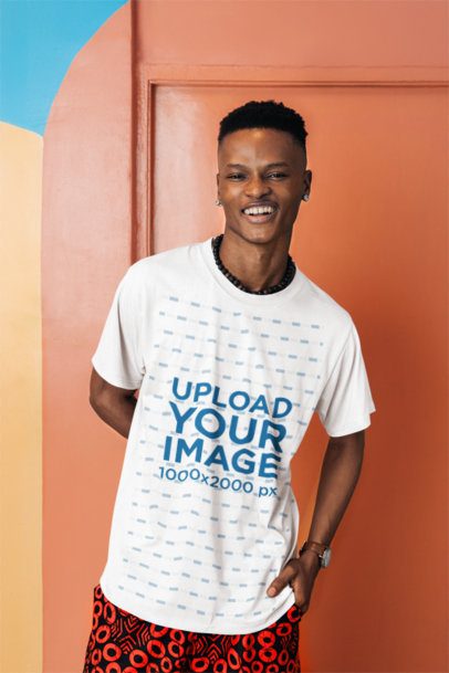 Round-Neck T-Shirt Mockup of a Man Posing With a Smile Against an Artsy Wall