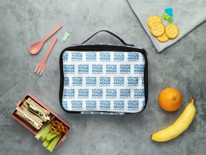 Mockup Featuring a Lunch Bag Placed on a Surface Surrounded by Snacks and Fruits m57817