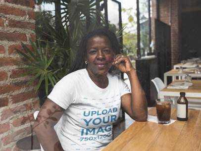 Mockup of a Woman Wearing a Round Neck T-Shirt at a Restaurant