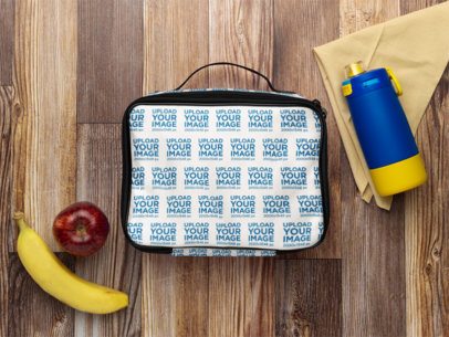 Lunch Bag Mockup Featuring a Wooden Table With Two Fruits and a Bottle m57819