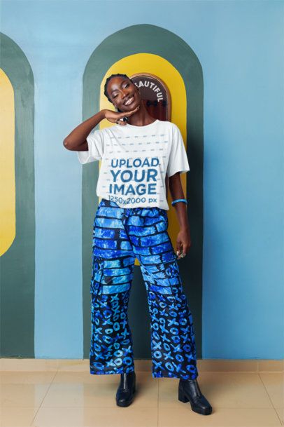 Round-Neck T-Shirt Mockup of a Smiling Woman Posing Against an Artsy Wall