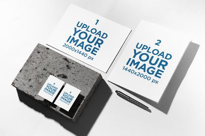 Mockup of a Paper Sheet Lying With a Folder Featuring Two Business Cards Over a Rock