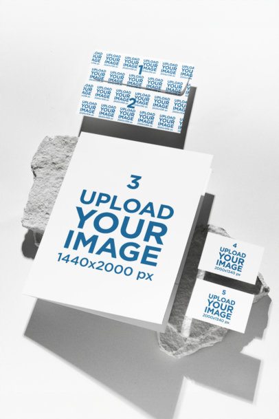 Stationery Mockup of an Envelope With a Folder and Two Business Cards Lying Over a Rock m57553