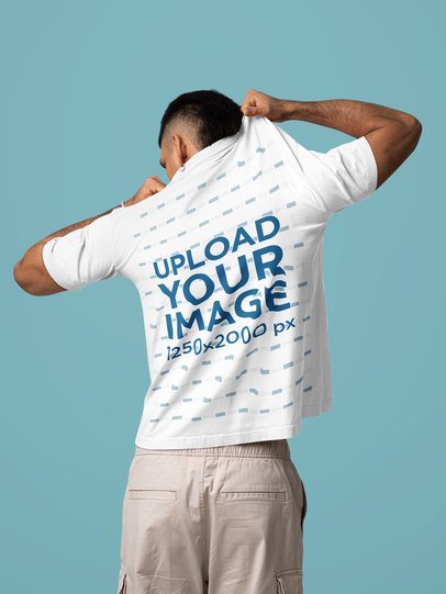 Back-View Mockup Featuring a Man Trying to Take Off His Oversized T-Shirt in a Studio m57444