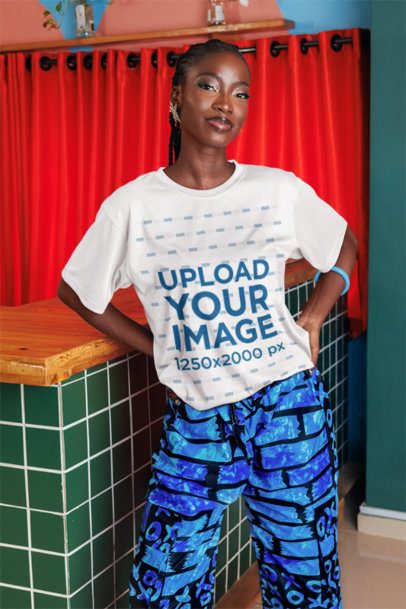 T-Shirt Mockup Featuring a Smiling Woman Posing With Her Hands on Her Waist in a Bar