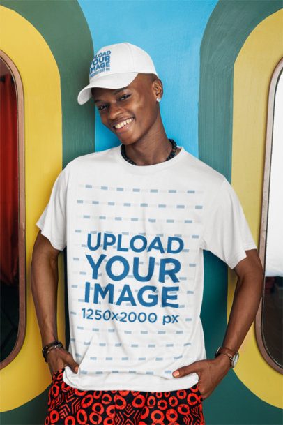 T-Shirt Mockup Featuring a Man Posing With a Dad Hat and a Happy Expression