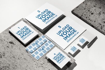 Hardcover Journal Mockup Lying on a Rock Surface With Business Cards and a Folder m57551