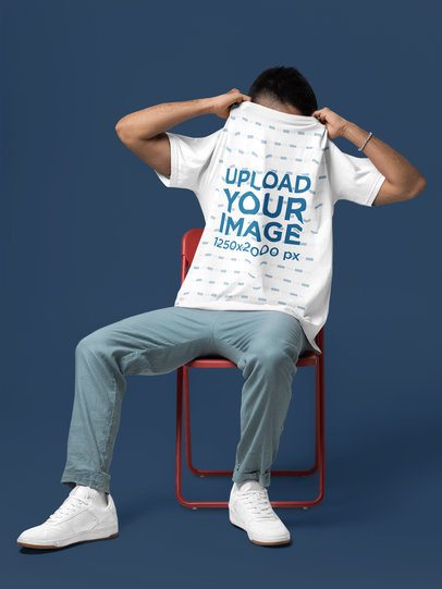 Comfort Colors Mockup of a Man Taking Off His Round-Neck T-Shirt in a Studio Setting m57436