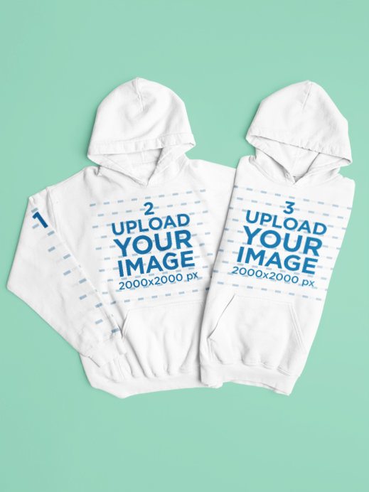 Mockup of Two Gildan Pullover Hoodies Lying on a Colorful Backdrop