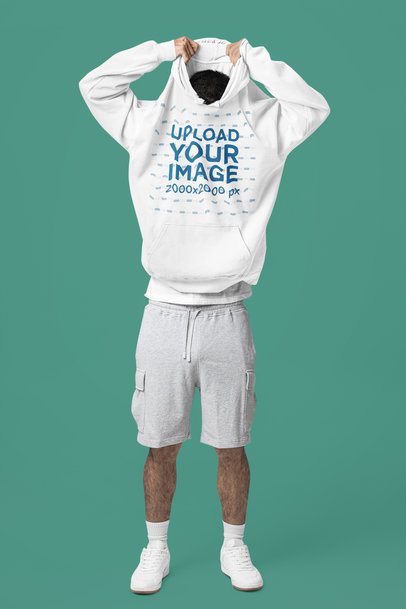 Comfort Colors Mockup Featuring a Man Taking Off His Pullover Hoodie in a Studio m57421