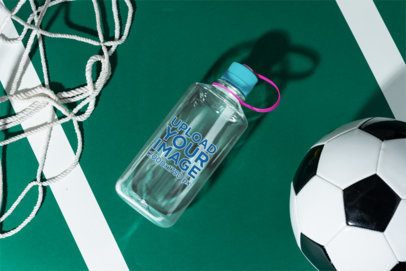 Mockup of a Narrow Mouth Plastic Water Bottle Lying on a Soccer Field With a Ball
