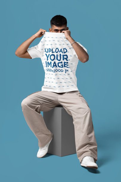 Mockup of a Man Covering His Face With an Oversized Round-Neck Tee in a Studio m57440