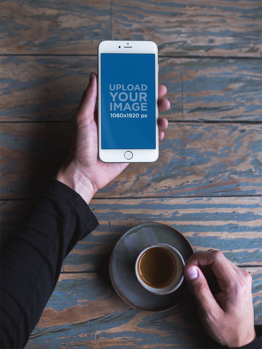 Mockup of a Man Holding a Silver iPhone 8 Plus and an Espresso