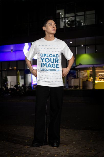 Oversized T-Shirt Mockup Featuring a Serious Man Posing on a Sidewalk m54211