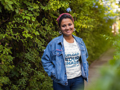 T-Shirt Mockup of a Woman Wearing a Denim Jacket Against Plants