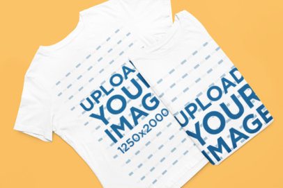 Mockup of Two Bella Canvas T-Shirts Lying on a Solid-Color Surface