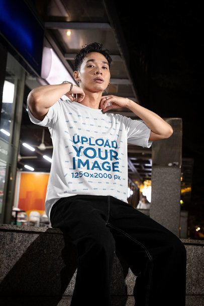 Oversized T-Shirt Mockup Featuring a Stylish Man Posing on the Sidewalk at Night m54209