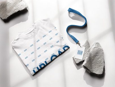 Oversized T-Shirt Mockup Featuring a Lanyard With a Badge Holder Placed on a Rock m58148