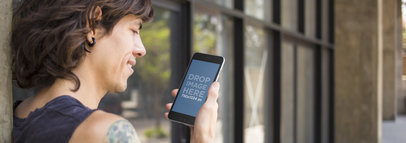 Urban Mockup of a Tattooed Man Using a Black iPhone 6 Plus in the City