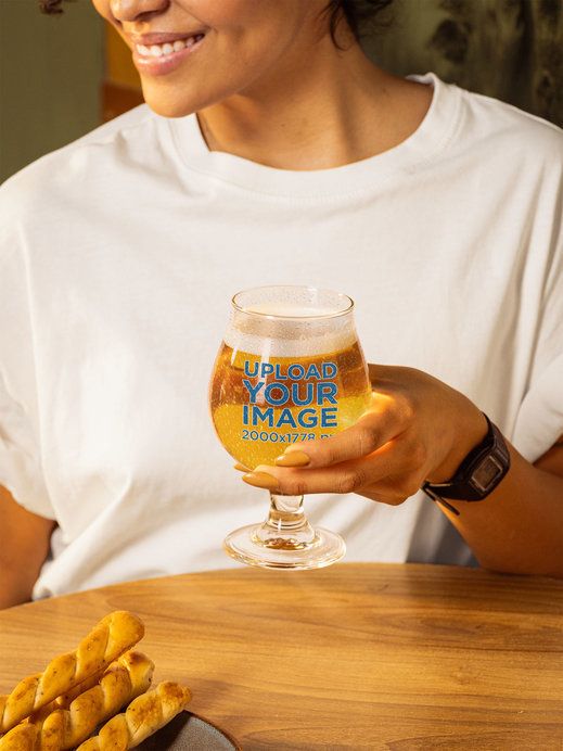 Mockup Featuring a Smiling Cropped-Face Woman Holding a Tulip Glass Filled With Beer