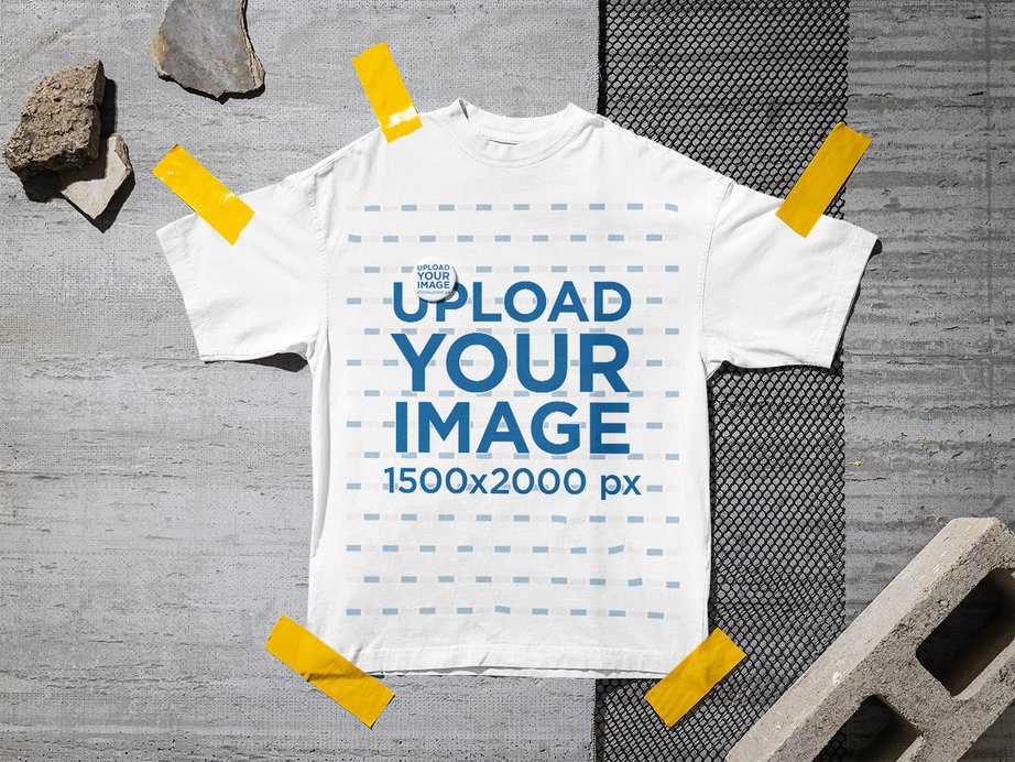 Mockup of an Oversized T-Shirt and a Pin Lying on an Urban Street Floor