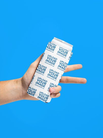 Mockup of a Person's Hand Holding a Koozie in a Colorful Setting m58393