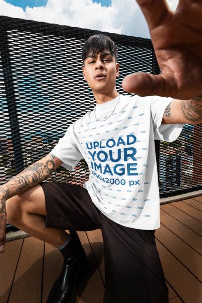 Oversized T-Shirt Mockup of a Tattooed Man Posing on a Balcony m57619