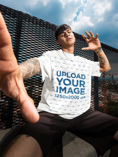 Oversized T-Shirt Mockup Featuring a Man With Tattoos Posing on a Roof m57620