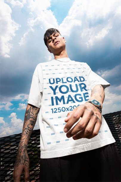 Oversized Tee Mockup of a Serious and Tattooed Man Posing Against the Sky m57622
