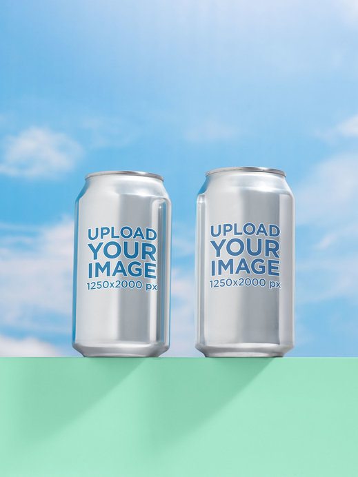 Mockup of Two 12 Oz Cans Placed on a Colorful Surface Against the Sky