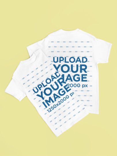 Mockup of Two Gildan Round-Neck Tees Lying on a Solid Color Surface