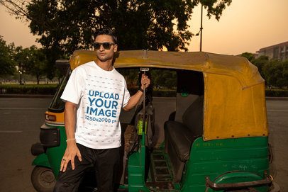 Mockup of a Man in an Oversized T-Shirt Posing Against a Cart Bike