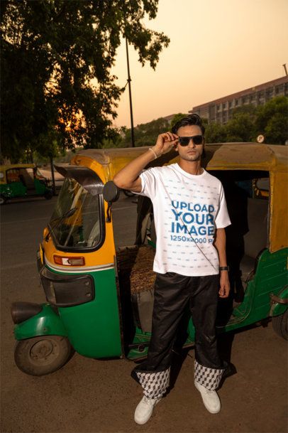 Oversized T-Shirt Mockup of a Man With Sunglasses Posing Against a Cart Bike