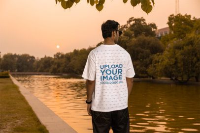 Back-View Mockup Featuring a Man in an Oversized Tee Walking in a Park