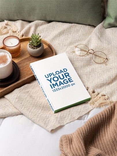 Mockup Featuring a Paperback Book Placed on a Cozy and Comfy Bed