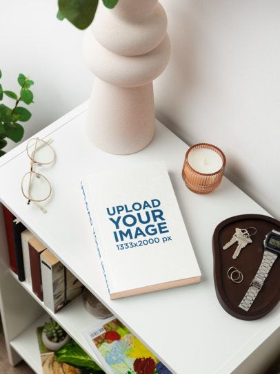 Mockup of a Paperback Book Lying on a Nightstand With a Pair of Glasses and Some Stuff