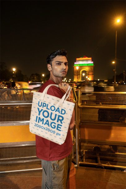 Tote Bag Mockup Featuring a Serious Man Walking on a Bridge at Night m56844