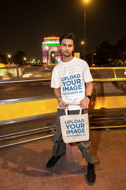 Oversized T-Shirt Mockup of a Serious Man Carrying a Tote Bag by the Street