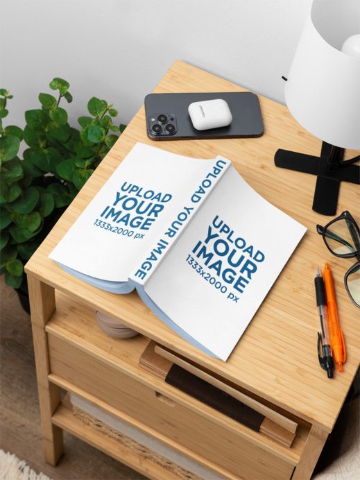Mockup of an Open Book Placed on a Wooden Nightstand