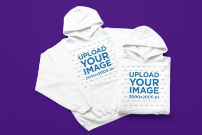 Gildan Mockup Featuring Two Pullover Hoodies Lying on a Colorful Surface m52199