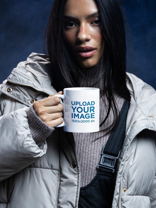 Coffee Mug Mockup Featuring a Woman Wearing Winter Clothes in a Cold-Inspired Setting