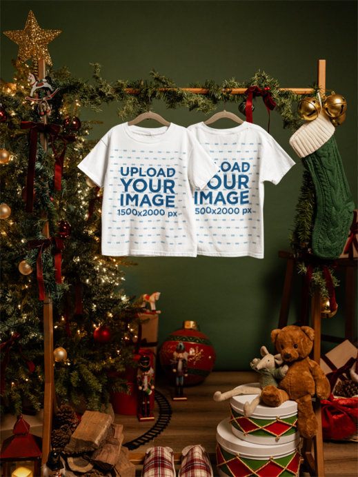 Mockup of Two Gildan 5000B Kids T-Shirts Hanging from a Garland-Decorated Rod