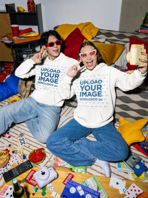 Comfort Colors 1567 Hoodie Mockup of a Happy Man and a Woman Taking a Selfie in a Living Room
