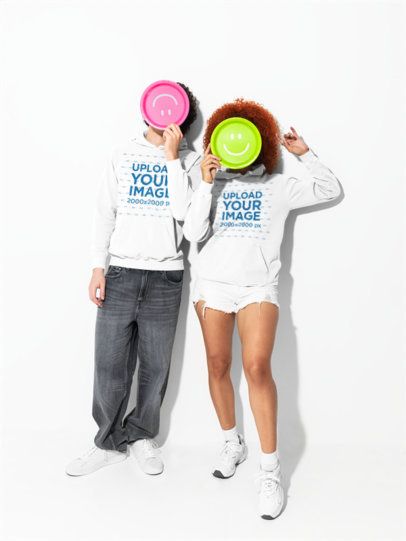 Comfort Colors 1567 Garment-Dyed Hoodie Mockups of Two Friends Holding Smiley Frisbees m59007