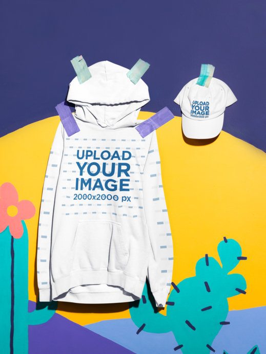 Mockup of a Comfort Colors 1567 Hoodie and Baseball Cap on a Colorful Hand-Painted Wall