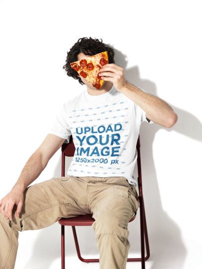 Mockup of a Man Wearing a Comfort Colors 1717 Garment-Dyed T-Shirt While Holding a Pizza Slice m59000