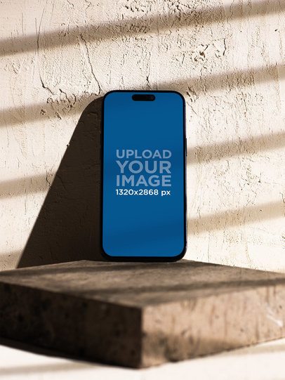 Mockup of an iPhone 17 Pro Max Placed Against a Texture Wall m59434