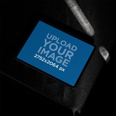 Mockup of an iPad on a Dark Textured Surface m59442