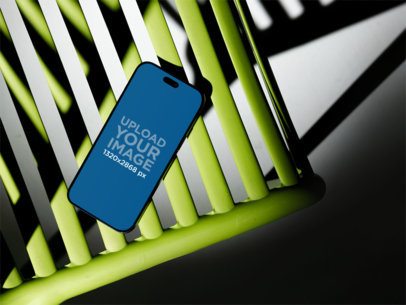 Mockup of an iPhone 17 Pro Max Placed on a Colorful Chair